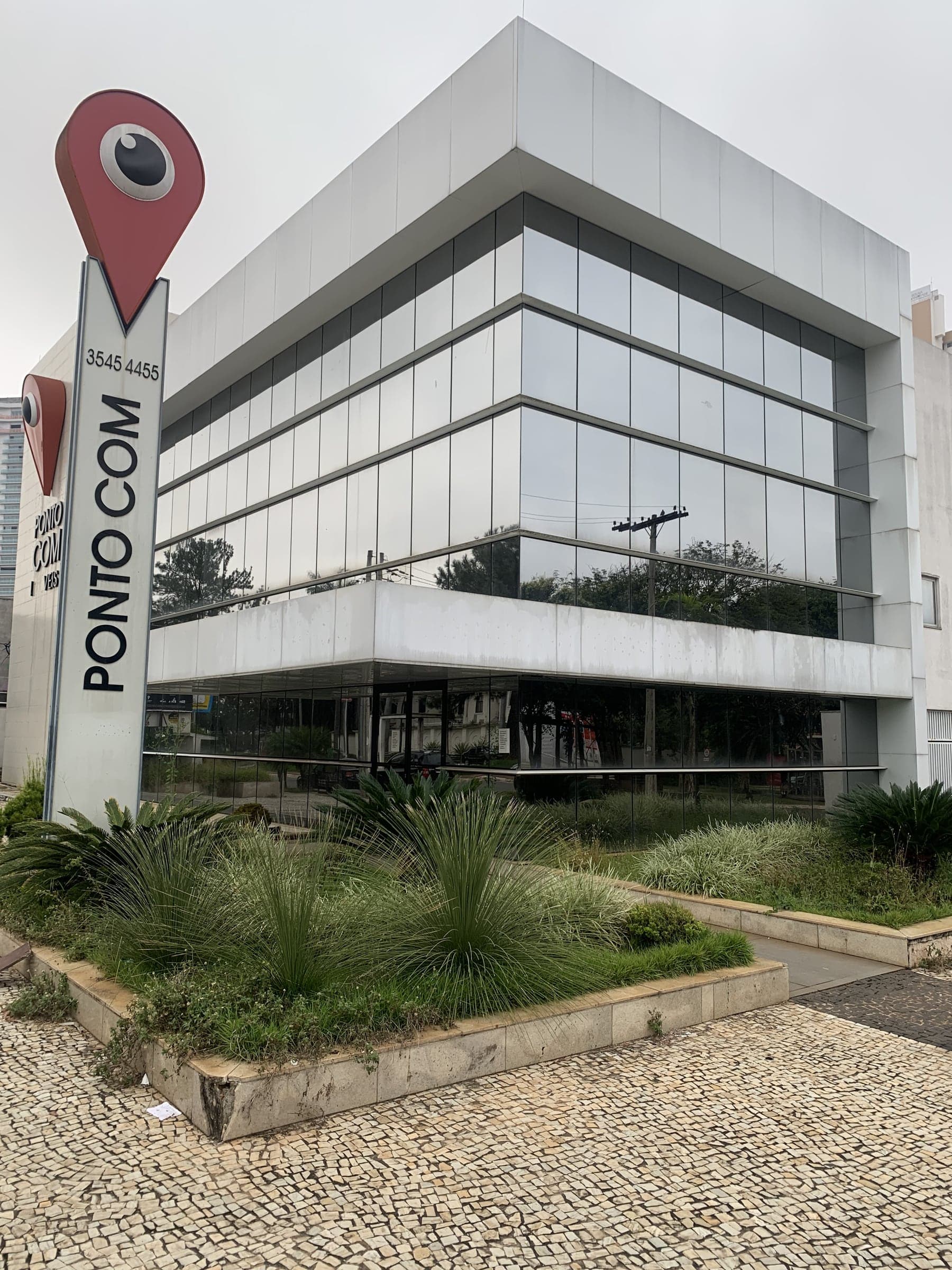 Edifício comercial com pele de vidro e térreo envidraçado